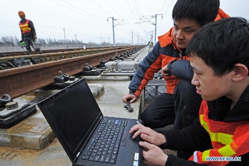 Engineers from China Academy of Railway Sciences collect data for the integration test in Huzhou, east China's Zhejiang Province, Feb. 26, 2013. The 150-kilometer Hangzhou-Ningbo high-speed railway linking Hangzhou and Ningbo, two hub cities in Zhejiang, commenced its integration test here on Friday. Once put into operation on July 2013 as expected, the high-speed railway that designed at a top speed of 350km/h, would reduce the travel time to 36 minitues, a quarter time of the current two-hour journey. (Xinhua/Tan Jin)  