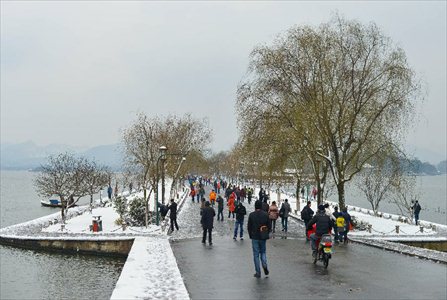 Tourists wonder by the West Lake after a snowfall in Hangzhou, capital of east China's Zhejiang Province, Feb. 8, 2013. A big range of snowfall enveloped Zhejiang Province on Friday. Photo: Xinhua