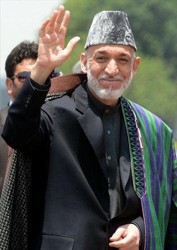 Afghan President Hamid Karzai waves as he arrives at New Delhi airport on Monday to attend the swearing-in ceremony. Leaders of all South Asian nations attended the ceremony.