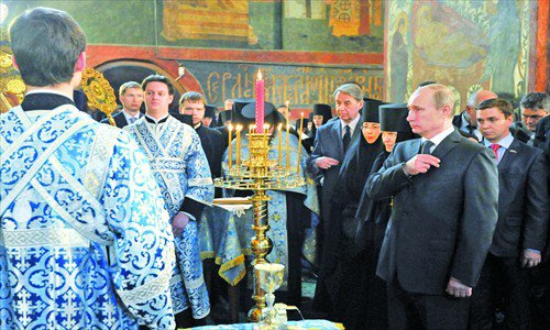 Russian president-elect Vladimir Putin makes the sign of the cross during a prayer at the Novo-Dyevitchi Convent in Moscow Sunday. Photo: AFP 