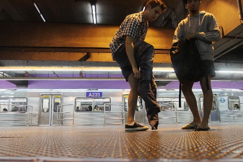 People take off their pants on a subway platform as they take part in the annual 