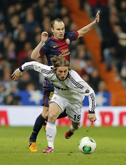 Luka Modric (No.19) of Real Madrid is challenged by Andres Iniesta of Barcelona on Wednesday.  Photo: CFP