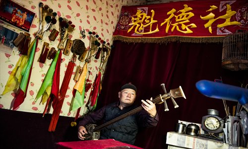 Yu Xiaozhang, a third-generation old Beijing traditional folk art performer, plays the sanxian, a plucked, three-stringed Chinese instrument. Photo: Li Hao/GT 