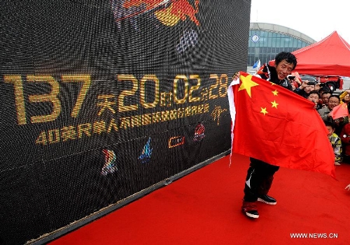 China's Guo Chuan celebrates with his world record in Qingdao, east China's Shandong Province, April 5, 2013. Guo sailed back home on Friday morning to become the first Chinese to successfully circumnavigate the globe singlehanded. Aboard his Class40 yacht, 48-year-old Guo travelled about 21,600 nautical miles in 138 days before he returned to his hometown of Qingdao, where he set off on November 18 last year. (Xinhua/Li Ziheng)