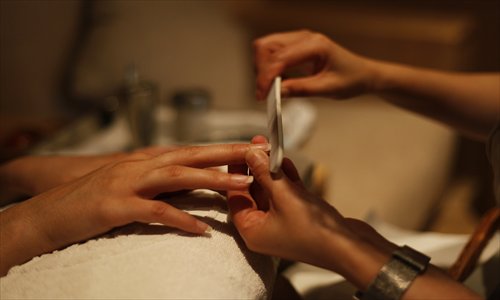 A technician at Subconscious Day Spa polishing a customer's nails.