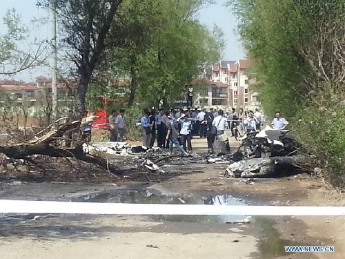 Photo taken on May 16, 2013 with a cellphone shows the site where a light plane failed to take off and crashed at Taoxian Airport in Shenyang, capital of northeast China's Liaoning Province. Three people on board were injured in the accident on Thursday. (Xinhua) 