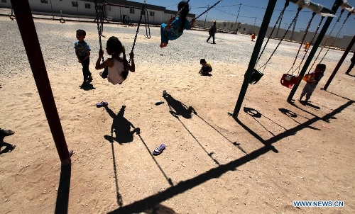 Syrian refugee children play on swings at the Mrajeeb Al Fhood refugee camp, 20 km (12.4 miles) east of the city of Zarqa April 29, 2013. The Mrajeeb Al Fhood camp, with funding from the United Arab Emirates, has received about 2500 Syrian refugees so far, according to the Red Crescent Society of the United Arab Emirates. (Xinhua/Mohammad Abu Ghosh) 