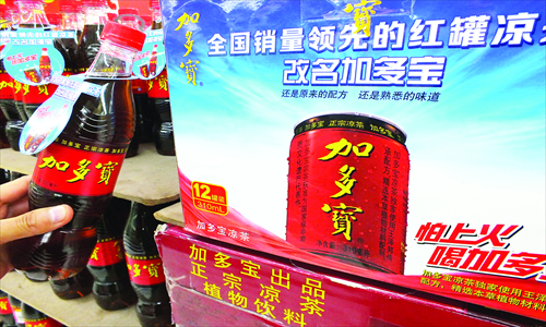 A bottle of JDB herbal tea is held by a customer in a store in Yichang, Hubei Province Tuesday. The beverages are produced by JDB Group, which lost a trademark case in July. JDB accounted for 73 percent of the herbal tea drinks market in the first three quarters of 2012, statistics showed Tuesday. Photo: CFP