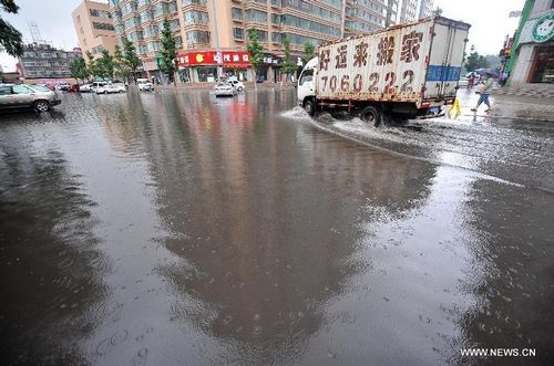 A van runs on a flooded road in Taiyuan, capital of North China's Shanxi Province, July 31, 2012. A downpour hit the city on Tuesday morning and caused urban waterlogging. Photo: Xinhua