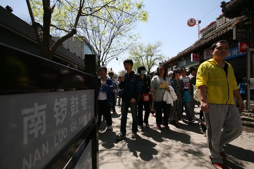 The Nangluoguxiang Hutong(Photo: CRIENGLISH.com/ Wang Zhi)A Hutong is a traditional alley, characteristic of an old Beijing city. A total of 7000 Hutongs have been built throughout the capital in straight lines under strict construction guildlines. The longest Hutong starts from the Beijing Legation Quarter, Dong Jiao Min Xiang,to the Xijiao Min Xiang, and has a total length of 6.5 kilometers, while the shortest Hutong is One-inch Street at only several meters' long. The narrowest Hutong is only about 0.7 meters wide. Therefore, people carrying even a little bit of extra weight have to hold their breath to pass through it. Formed during the Yuan, Ming and Qing, dynasties thousands of Hutongs surround the supreme Imperial Palace from all directions. They are woven into the fabric of people's daily lives.