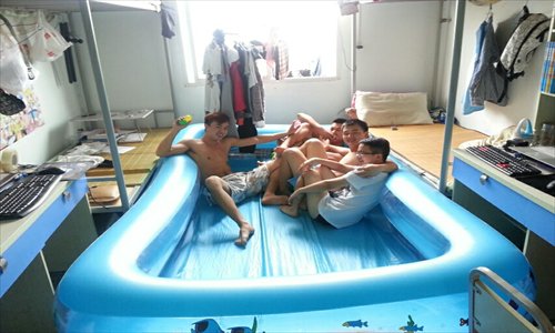 Sichuan University of Science and Engineering students rest before filling the pool they just installed in their dorm room. They hope their new investment will help them stay cool as summer temperatures continue to rise. Photo: CFP