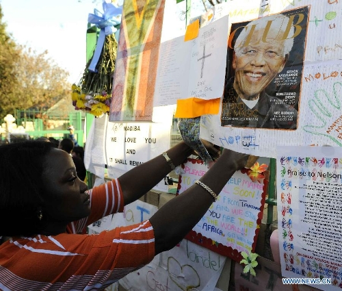 A local resident pastes a card on a wishing board outside the hospital where South Africa's anti-apartheid icon Nelson Mandela is treated in Pretoria, South Africa, to pray for Mandela, June 26, 2013. South Africa's President Zuma said on Wednesday that Mandela's condition 