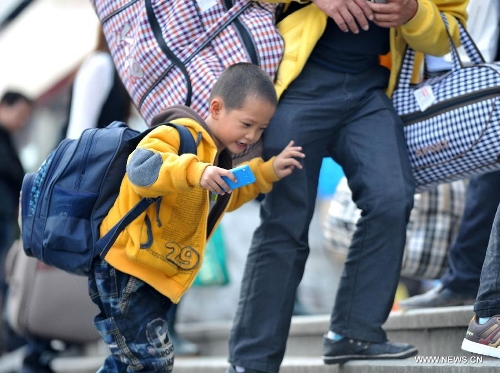 A little boy carrying a bag enters the Nanning train station in Nanning, capital of south China's Guangxi Zhuang Autonomous Region, Feb. 3, 2013. Many children travel with their families during the 40-day Spring Festival travel rush which started on Jan. 26. The Spring Festival, which falls on Feb. 10 this year, is traditionally the most important holiday of the Chinese people.Public transportation is expected to accommodate about 3.41 billion travelers nationwide during the holiday, including 225 million railway passengers. (Xinhua/Zhou Hua)