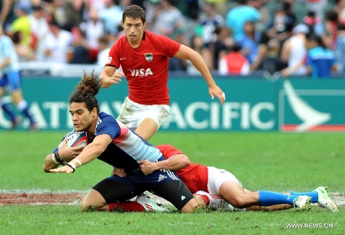 Vincent Inigo (L) of France vies during a match against Argentina at the Hong Kong Sevens rugby tournament in south China's Hong Kong, March 24, 2013. France won the match 19-14 to win the 13th place. (Xinhua/Lo Ping Fai) 