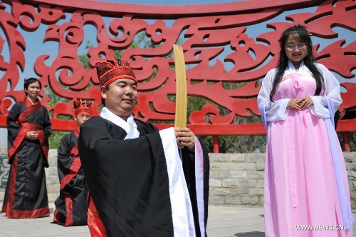 Yao Yuan (L front), who is fond of the Han Chinese culture, holds a sacrificial ceremony for Qu Yuan, a patriotic poet during the Warring State Period (475-221 BC), during a celebration activity of the Dragon Boat Festival, in Lanzhou, capital of northwest China's Gansu Province, June 12, 2013. Wednesday marks the Dragon Boat Festival, a festival which falls on May 5 each year in lunar calendar in China. Local residents in Lanzhou held a series of celebration activities by the riverside of the Yellow River on this day. (Xinhua/Chen Bin) 