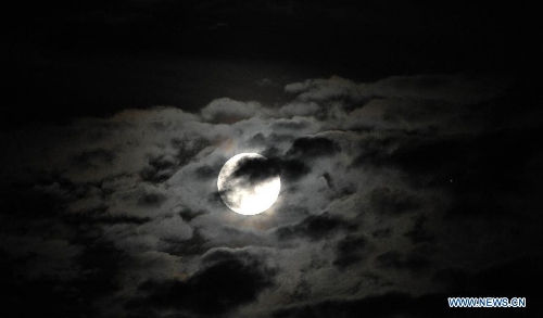 A full moon is seen surrounded by cloud in Haikou, capital of south China's Hainan Province, June 23, 2013. The moon looks 14 percent larger and 30 percent brighter than usual on Sunday. The scientific term for the phenomenon is 