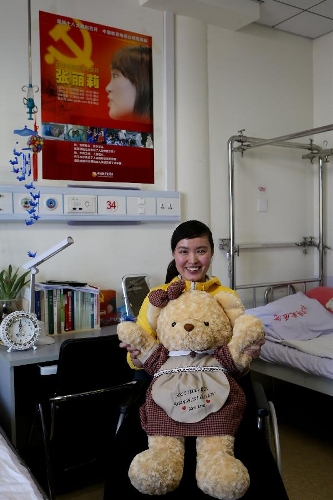 Zhang Lili, a teacher who lost her legs while saving two students from an onrushing bus, sits on her wheel chair at the China Rehabilitation Research Center in Beijing, capital of China, Jan. 7, 2013. Zhang, who successfully pushed the students out of the harm's way but unable to avoid the bus herself and lost her legs in the accident, has been receiving rehabilitative treatment here for over 4 months. Zhang makes great efforts now in order to be able to walk again. (Xinhua/Jin Liwang) 