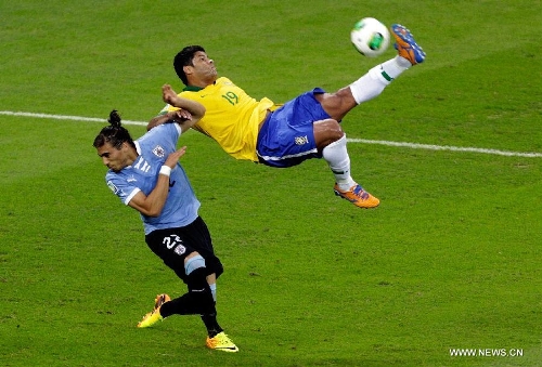 Brazil's Hulk (R) vies for the ball with Martin Caceres (L) of Uruguay, during the FIFA's Confederations Cup Brazil 2013 semifinal match, held at Mineirao Stadium, in Belo Horizonte, Minas Gerais state, Brazil, on June 26, 2013. (Xinhua/David de la Paz)