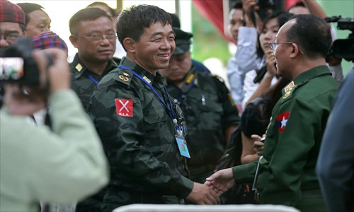 Deputy commander-in-chief of the Kachin Independence Army (KIA) (center left), shakes hands with a senior Myanmar military official (right) as they meet for talks in the Kachin state capital on Tuesday. A senior UN envoy attended the first talks between the two sides on home soil since a deadly ethnic conflict nearly two years ago.Photo: AFP