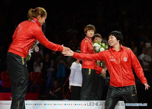  Gold medalist Li Xiaoxia (R) of China shakes hands with her teammate Liu Shiwen during the awarding ceremony for women's singles at the 2013 World Table Tennis Championships in Paris, France on May 19, 2013. Li claimed the title by defeating her teammate Liu Shiwen with 4-2. (Xinhua/Tao Xiyi) 