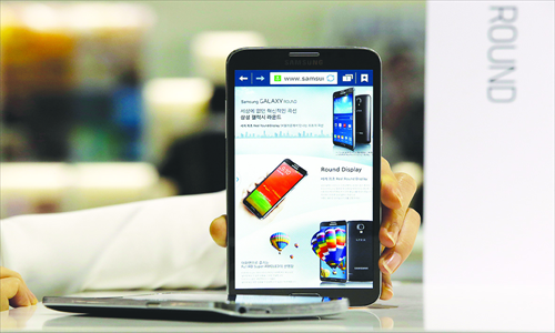 A model (unseen) holds up Samsung's curved smartphones in Seoul on October 10. Photo: IC