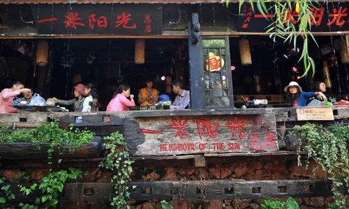 Tourists entertain themselves at a bar in the old town of Lijiang, southwest China's Yunnan Province, Aug. 8, 2012. The old town of Lijiang, a UNESCO World Heritage site with a history of more than 800 years, was formally licenced as the national 5A tourism attraction spot, the top one among China's tourism ranking system, on July 27, 2011. During the first six months of 2012, in total 8.0934 million people visited Lijiang, increasing by 55.93 percent year on year. The tourism industry's revenue of the same period reached 10.395 billion yuan ($1.634 billion), growing by 56.14 percent. Photo: Xinhua