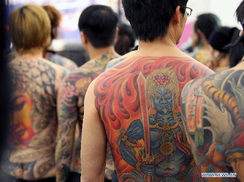 People from Asia show their tattoo during the 21st International Tattoo Convention in Frankfurt, Germany, March 22, 2013. The Tattoo Convention kicked off on Friday and will last for three days. (Xinhua/Luo Huanhuan)