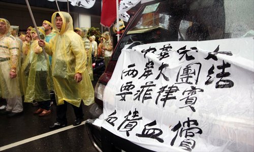 Members of a non-governmental group China Patriotic Association protest alongside fishermen from Pingdong, Taiwan outside the Manila Economic and Cultural Office in Taipei on May 13. The pictured banner reads “Chinese mainland and Taiwan should join to urge the Philippines to apologize for the death of the fisherman and offer compensation.” Photo: China News Service