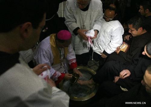 Latin Patriarch of Jerusalem Fouad Twal (L) washes the foot of a priest during the Catholic Washing of the Feet ceremony in the Church of the Holy Sepulchre in Jerusalem's Old City during Holy Week on March 28, 2013. Holy Week is celebrated in many Christian traditions during the week before Easter. (Xinhua/Muammar Awad) 