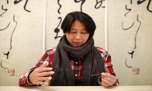 Sun Guang'e burns an agarwood incense stick and enjoys the aroma. Photo: Cai Xianmin/GT