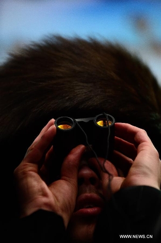 A Jewish man of the Belz Hasidic Dynasty uses a binocular to watch the wedding ceremony of Rabbi Shalom Rokeach, the grandson of the Belz Rabbi Yissachar Dov Rokeach, at the neighbourhood of Kiryat Belz in Jerusalem on May 21, 2013. More than 10,000 Jews participated in the wedding. (Xinhua/Yin Dongxun) 