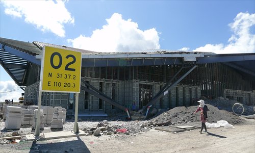 A worker walks on June 25 past a building that is going to be part of the airport under construction in Shennongjia, Hubei Province. Photo: Liu Dong/GT