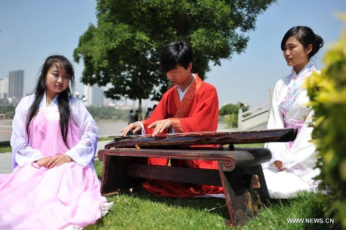 People play Guqin, a seven-stringed plucked instrument popular in ancient China, during a celebration activity of the Dragon Boat Festival, in Lanzhou, capital of northwest China's Gansu Province, June 12, 2013. Wednesday marks the Dragon Boat Festival, a festival which falls on May 5 each year in lunar calendar in China. Local residents in Lanzhou held a series of celebration activities by the riverside of the Yellow River on this day. (Xinhua/Chen Bin) 