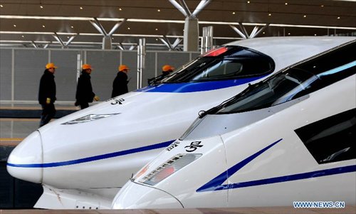 Workers walk past high-speed trains at the Zhengzhou East Railway Station in Zhengzhou, capital of central China's Henan Province, December 18, 2012. The Beijing-Zhengzhou high-speed railway will start service on December 26, connecting the functioning Zhengzhou-Wuhan and Wuhan-Guangzhou high-speed railway to become the world's longest high-speed railway. The new station is the biggest high-speed railway marshalling station of central China as well as a comprehensive passenger tranportation hub incorporating high-speed railway, road transportation, intercity railway, subway and bus. Photo: Xinhua