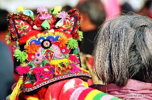  A grandma holds her grandchild who wears a traditional tiger hat as they head for a New Year fair in Tuocheng County, central China's Henan Province, Jan. 20, 2004. People living in the central China's region usually follow a tradition to wear new clothes and children are dressed with tiger hats or shoes to ward off eveil spirits during the Spring Festival or Chinese Lunar New Year. (Xinhua/Wang Song)