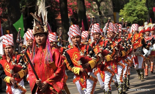 Young people of the Jingpo ethnic group perform at a carnival during the China Kunming Culture and Tourism Festival in Kunming, capital of southwest China's Yunnan Province, April 29, 2013. (Xinhua/Lin Yiguang)  