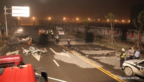 Rescuers work at the accident site after a car with eight passengers collided with a trailer in Wenzhou City, east China's Zhejiang Province, May 12, 2013. Seven people were killed and one other injured in the accident, which ocurred at midnight on Saturday. (Xinhua)