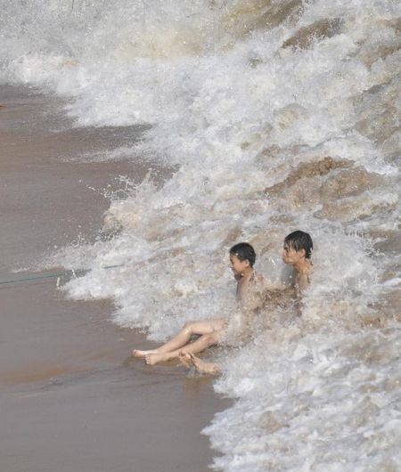 Visitors enjoy the waves as tropical storm Damrey approaches along coastal areas in Qingdao, East China's Shandong Province, August 1, 2012. Damrey is expected to land on the coast of Jiangsu and Shandong provinces on Thursday night or Friday morning. Photo: Xinhua