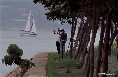 Two visitors take pictures at the Ping Chau Island in south China's Hong Kong, May 12, 2013. Ping Chau, also named Tung Ping Chau, lies in the northeast corner of Hong Kong and is part of the Hong Kong Geopark. The island is home to shale rocks in various shapes which makes it a popular tourist attraction. (Xinhua/Chen Xiaowei) 