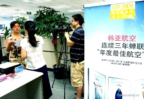 An employee is interviewed by reporters at the office of the Asiana Airlines to Shanghai, east China, July 7, 2013. A total of 141 Chinese citizens were among the 291 passengers aboard the Asiana Airlines flight that crash-landed at the San Francisco International Airport on Saturday, and 90 of the Chinese passengers in total departed from Shanghai via Seoul to the San Francisco airport in the U.S. All the two killed in the crash were identified to be Chinese women, South Korea's transportation ministry said Sunday. (Xinhua/Chen Fei)  