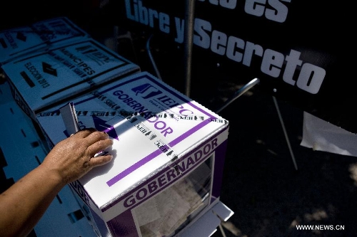 A citizen casts his vote during the election day in Tijuana, Baja California, Mexico, on July 7, 2013. On Sunday, elections took place in Mexico's 14 states, where state legislatures and mayorships would be renewed. (Xinhua/Guillermo Arias) 