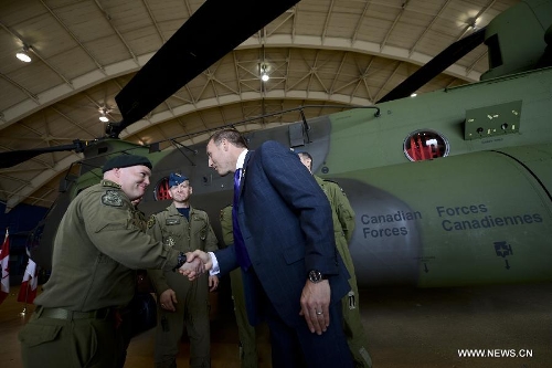 Canadian Defense Minister Peter MacKay (R) shakes hands with a pilot from the Royal Canadian Air Force during the unveiling of new CH-147F Chinook helicopters in Ottawa June 27, 2013. The 15 newly purchased F-model Chinooks will be engaged in support, domestic and foreign operations for the Royal Canadian Air Force's reactivated 