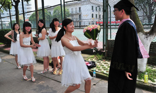 A female university student seizes the last opportunity to express her love through flowers to a male student, during a graduation ceremony at a university in Ganzhou, Jiangxi Province, on Monday. Photo: CFP
 