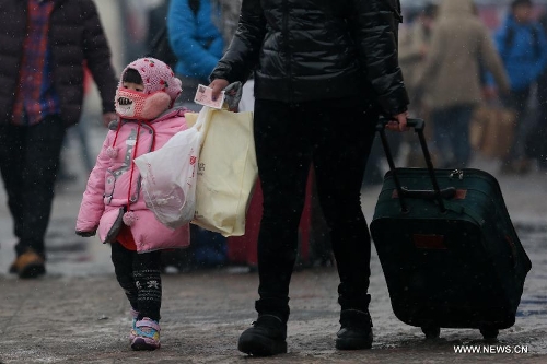 A girl and her mother walks at the Beijing train station in Beijing, capital of China, Feb. 3, 2013. Many children travel with their families during the 40-day Spring Festival travel rush which started on Jan. 26. The Spring Festival, which falls on Feb. 10 this year, is traditionally the most important holiday of the Chinese people.Public transportation is expected to accommodate about 3.41 billion travelers nationwide during the holiday, including 225 million railway passengers. (Xinhua/Jin Liwang)