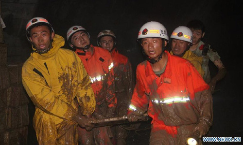 Firefighters rescue a citizen at an accident site after a road collapsed at Liaoyang street of Harbin city, Northeast China's Heilongjiang Province, August 14, 2012. Two people were confirmed dead and two others injured when a roadbed collapsed at Liaoyang Street in Nangang district of Harbin city on Tuesday. Photo: Xinhua