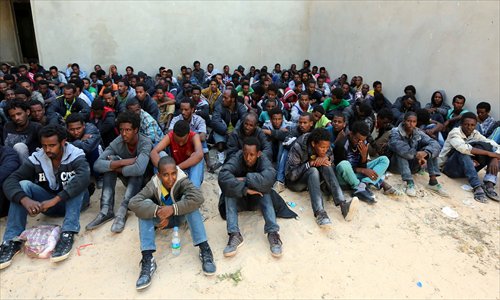 Some of the 340 illegal migrants who were rescued by the Libyan navy off the coast of the western town of Sabratha when their boat began to take on water, sit at a shelter on Monday in the coastal town of Zawiya, west of Tripoli. Libya has long been a springboard for Africans seeking a better life in Europe, and the number of illegal departures from its shores is rising. Photo: AFP