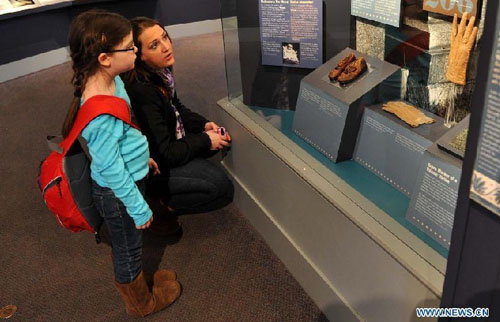 Visitors look at a pair of shoes of Sidney Leslie Goodwin at the Maritime Museum of the Atlantic in Halifax, Canada, April 14, 2012. Sidney Goodwin was a 19-month-old English boy who died during the sinking of the Titanic. For decades he was referred to as 