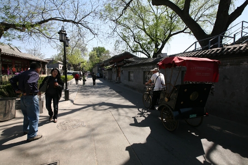 A Hutong in Shichahai(Photo: CRIENGLISH.com/ Wang Zhi)A Hutong is a traditional alley, characteristic of an old Beijing city. A total of 7000 Hutongs have been built throughout the capital in straight lines under strict construction guildlines. The longest Hutong starts from the Beijing Legation Quarter, Dong Jiao Min Xiang,to the Xijiao Min Xiang, and has a total length of 6.5 kilometers, while the shortest Hutong is One-inch Street at only several meters' long. The narrowest Hutong is only about 0.7 meters wide. Therefore, people carrying even a little bit of extra weight have to hold their breath to pass through it. Formed during the Yuan, Ming and Qing, dynasties thousands of Hutongs surround the supreme Imperial Palace from all directions. They are woven into the fabric of people's daily lives.