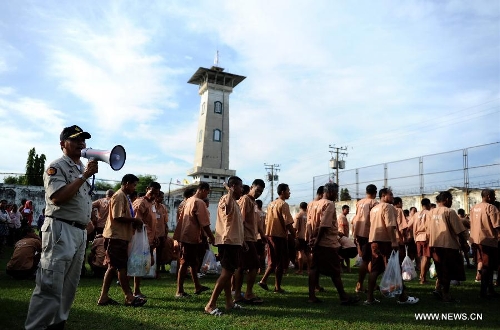 Unshackled prisoners walk past a prison guard at Central Bangkwang Prison in Nonthaburi Province, Thailand, on May 15, 2013. More than 500 prisoners who committed serious crimes have had the handcuffs and foot shackles removed in Thailand. (Xinhua/Gao Jianjun) 