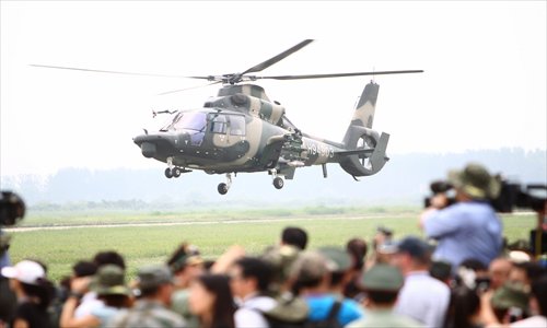 Journalists from home and abroad take photos of a military helicopter from the Fourth Helicopter Regiment of the People's Liberation Army (PLA) Army Aviation in the eastern suburb of Beijing on Tuesday.
It is the fifth time that the media have been invited to view PLA units prior to Army Day, which falls on August 1. Photo: CFP